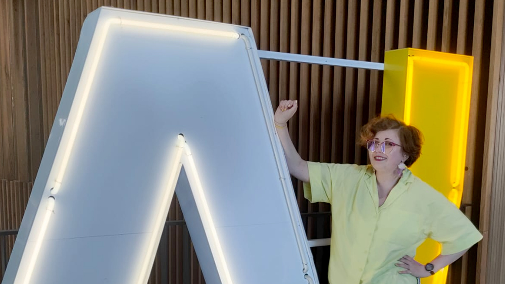 2025_06_aalto Kira Vesikko posing in front of the Aalto University A! sign