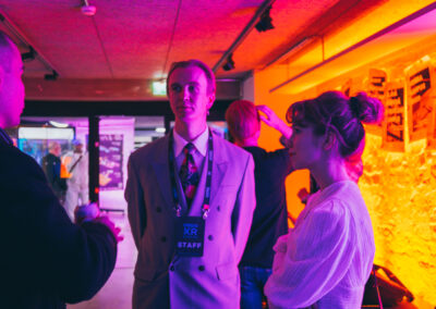 People at an event, bathed in sharp orange light.